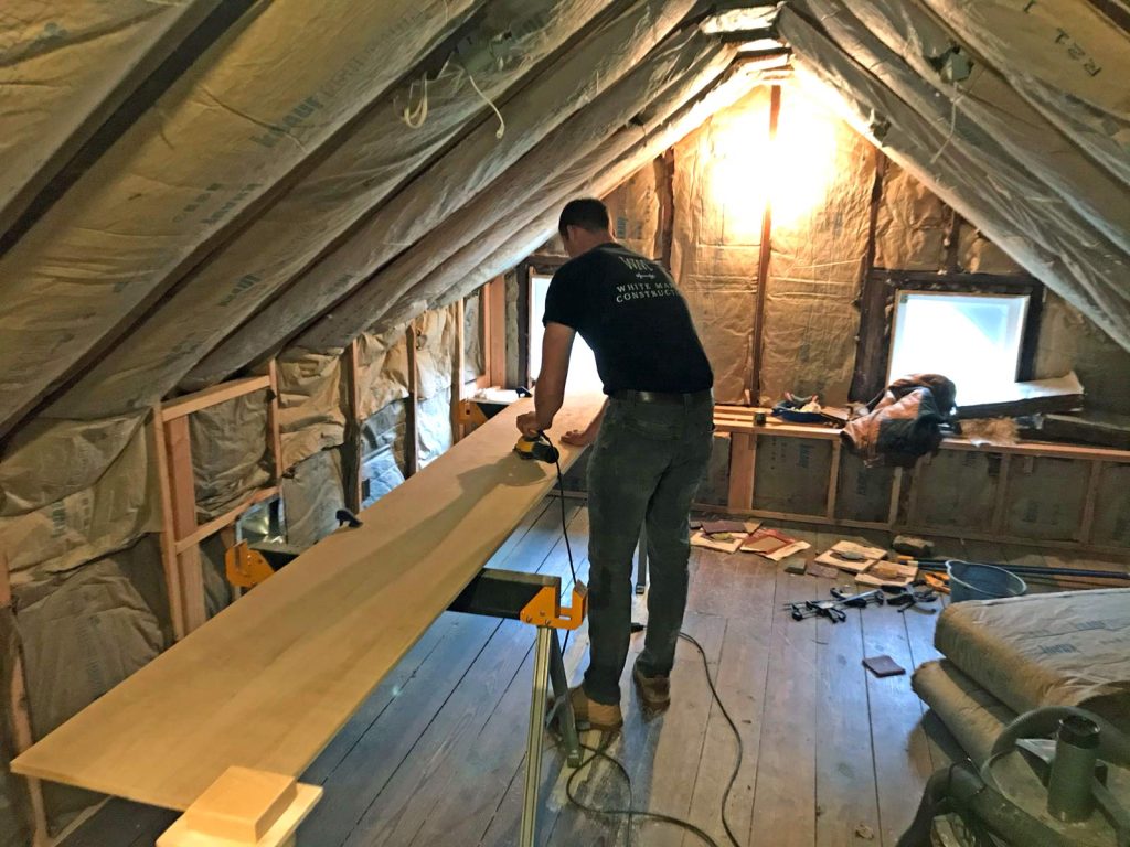 The team at White Maple Construction sanding wood in the attic