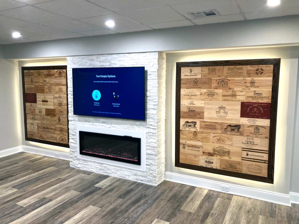 A recently completed basement renovation with a fireplace and wine crate walls by White Maple Construction