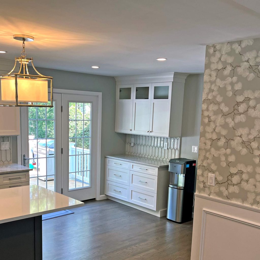 A modern kitchen remodel with white cabinets and wood floors by White Maple Construction