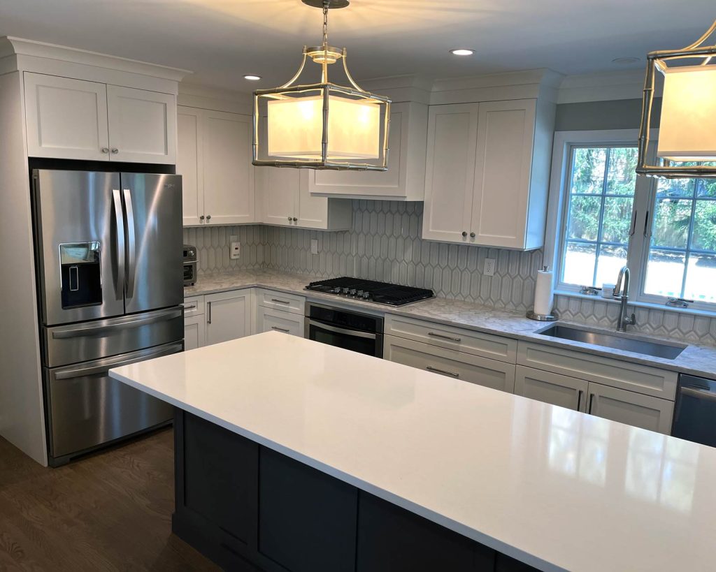 A modern kitchen remodel with white cabinets and wood floors by White Maple Construction