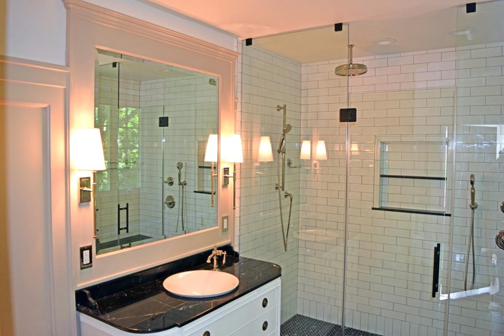 A modern white bathroom with white subway tiles by White Maple Construction